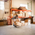 Worker Lifting Cardboard Box