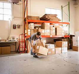 Worker Lifting Cardboard Box