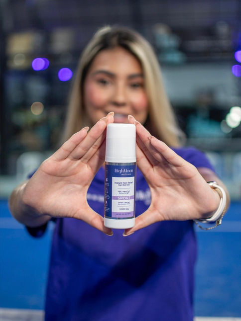 A woman holding up a HighMoon Wellness cream