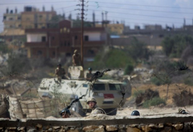 Egyptian army forces patrol amid debris of houses destroyed by the army in the E