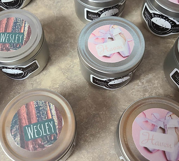 Candles with two different book character names and trees for one, ballet slippers for the other