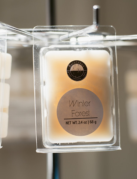Wax melts hanging on a metal rack next to a window