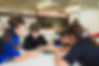 Four primary students collaborating on a colourful puzzle at a classroom table.