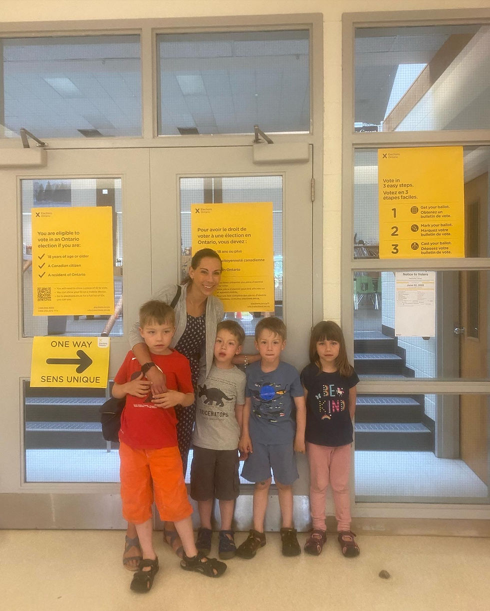 Family standing in front of voting information posters