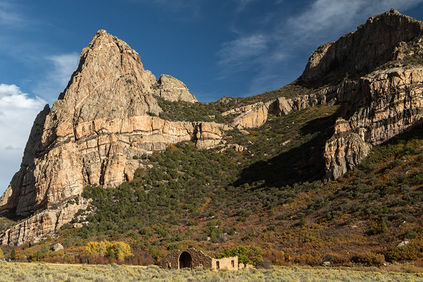 Photo of the amazing geology of Thimble Rock towering over the ruins of Driggs Mansion in southwestern Colorado