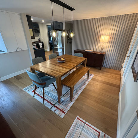 Dining room with table, chairs, bench and striped rugs RDM Construction
