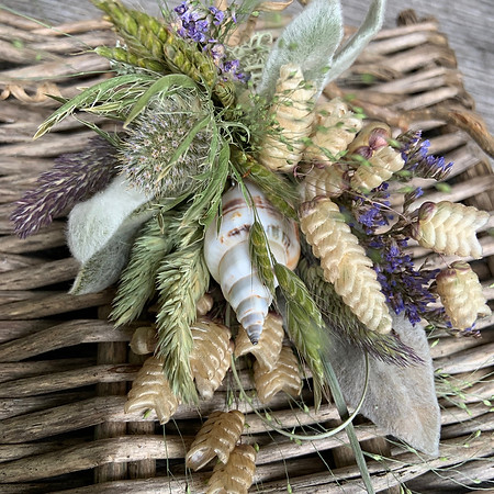 Corsage of dried leaves and ears of corn with a seashell
