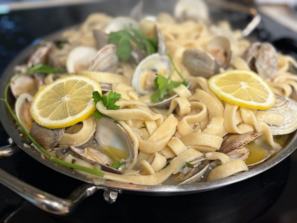 Eye-level view of a plate of linguini with clams garnished with parsley and lemon zest