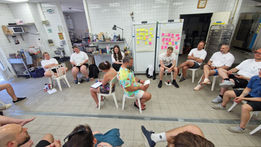 Audrey Zander leadership communication coach | A team sat in circle, with two colleagues in the center, working on how to improve team culture with Audrey Zander, leadership coach in Cannes, Nice and Monaco