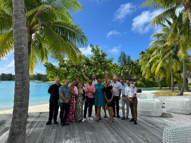 Audrey Zander leadership communication coach | Multicultural team building and communication coaching with Audrey Zander, showing the team outside under palm trees