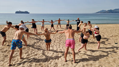 Audrey Zander leadership communication coach | A team offsite and leadership training with Audrey Zander, executive coach in Cannes, where we see the team placed in a circle on the beach