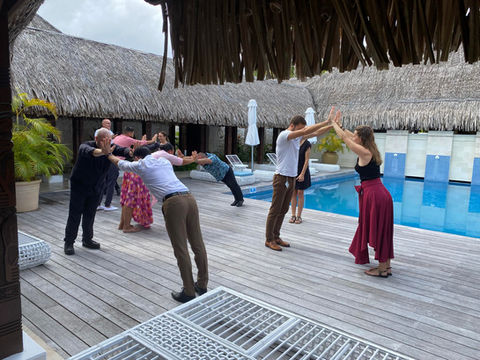 Audrey Zander leadership communication coach | Picture of a team retreat with Audrey Zander, leadership coach Cannes, exploring how to improve team culture and psychological safety at work. It shows a team matched in pairs, that have to physically rely on each other to stay standing.