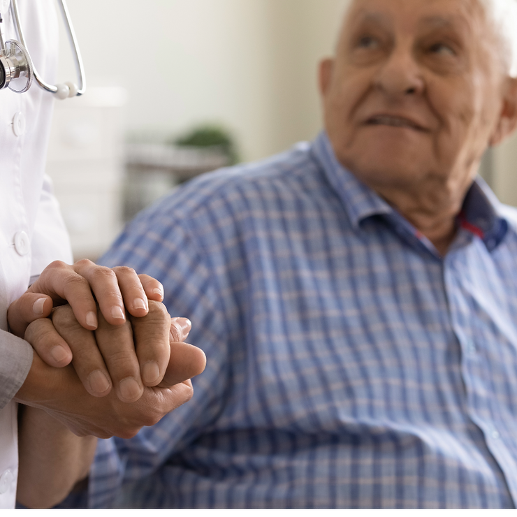 Older man holding caregiver's hand