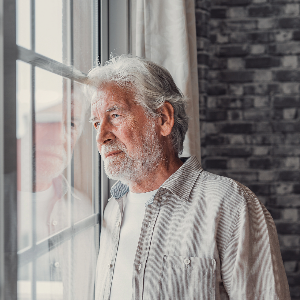 Senior man looking out window