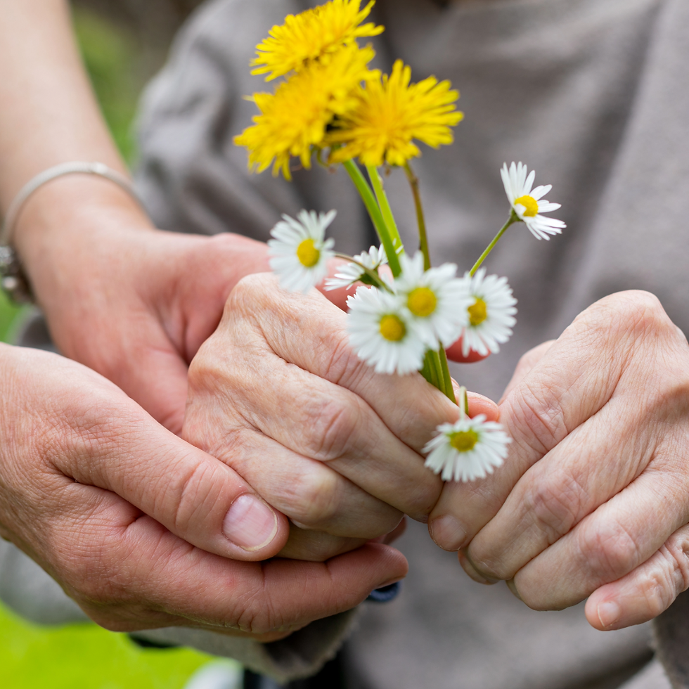 Nurse and senior holding flowers