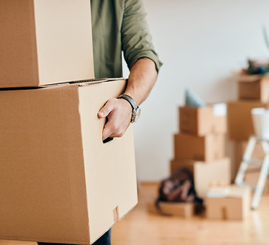closeup-man-carrying-cardboard-boxes-while-relocating-into-new-apartment.jpg