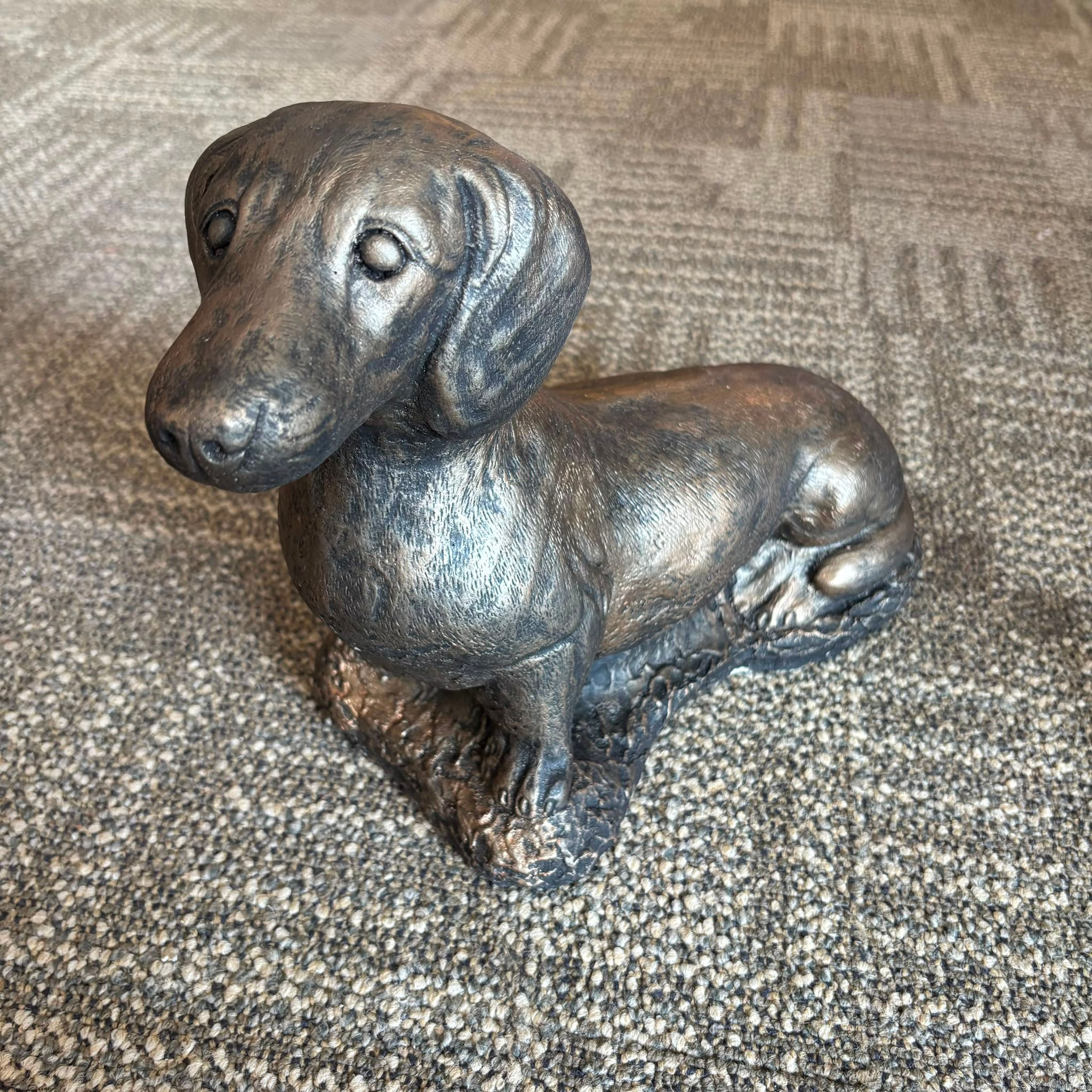 Stone, sausage dog, with a bronzed or antiqued metallic finish ornament