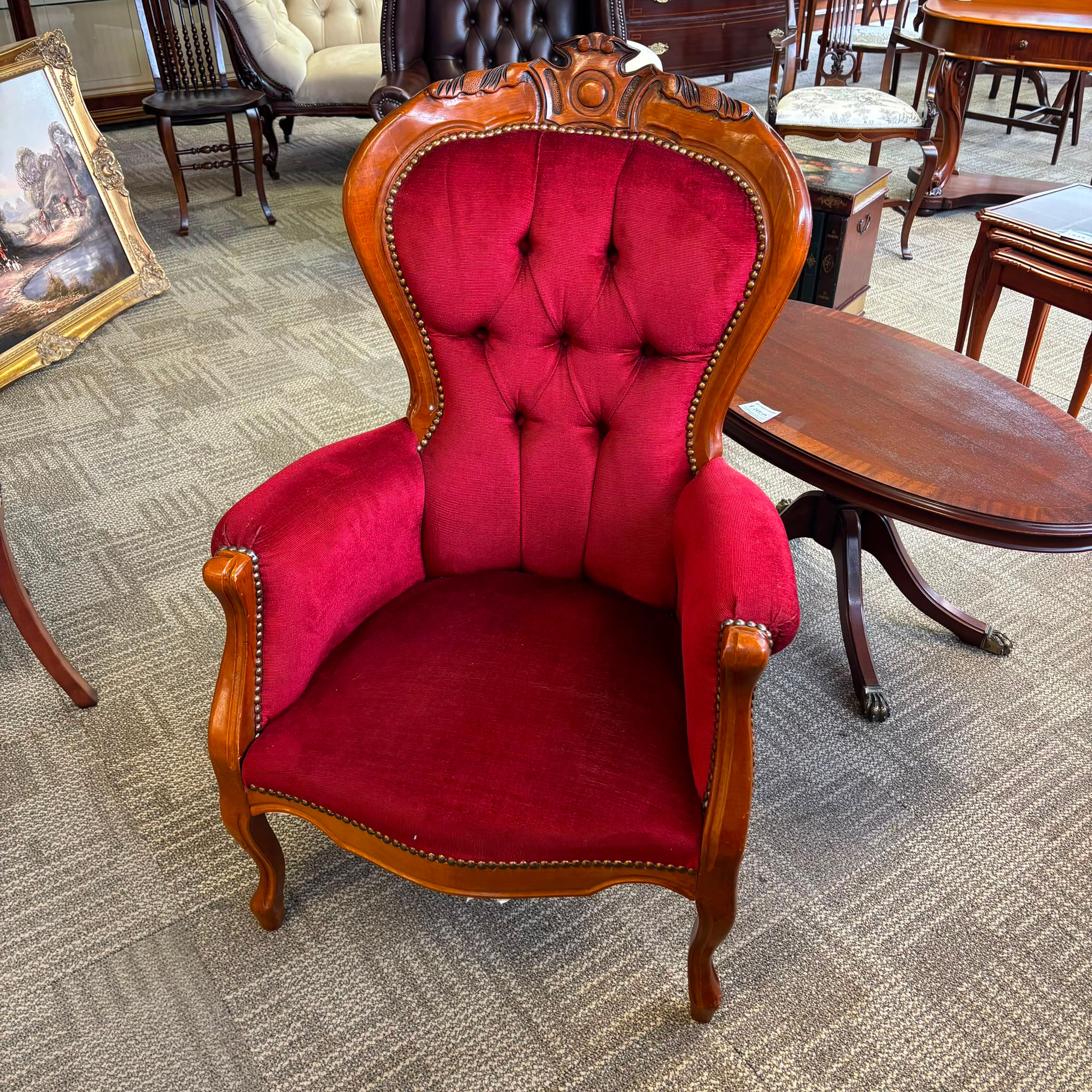 Victorian mahogany armchair with a carved, deep button-back upholstery in red