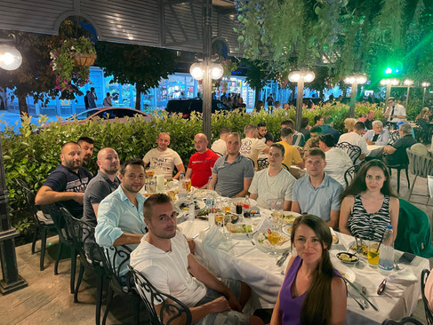 the whole team gathered at a table in a big restaurant