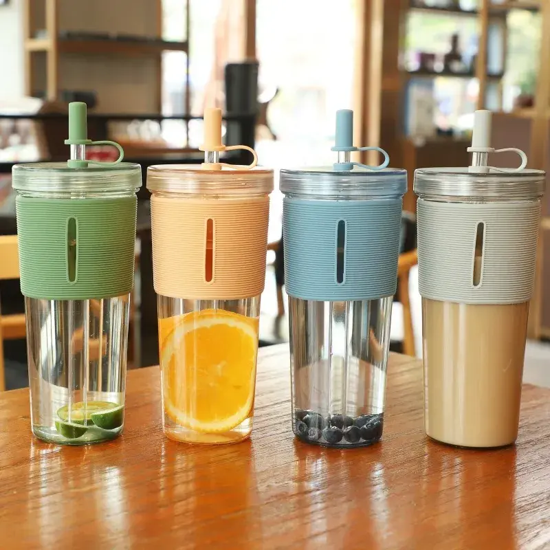 Four reusable glass tumblers with silicone sleeves and straws