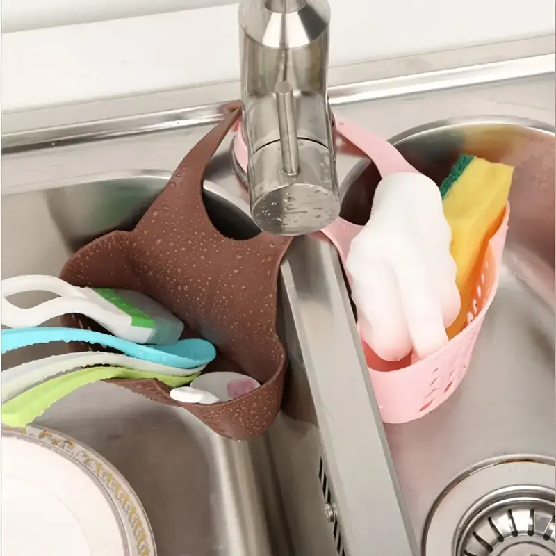Kitchen sink caddy hanging on faucet with sponges