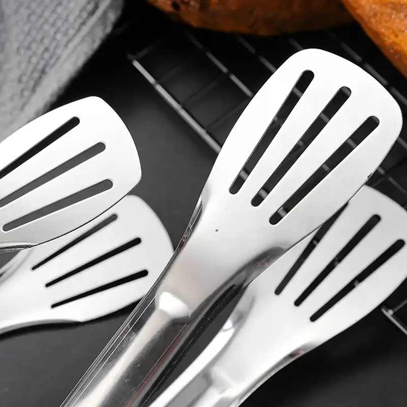 Thumbnail: Stainless steel slotted kitchen tongs on a grill rack
