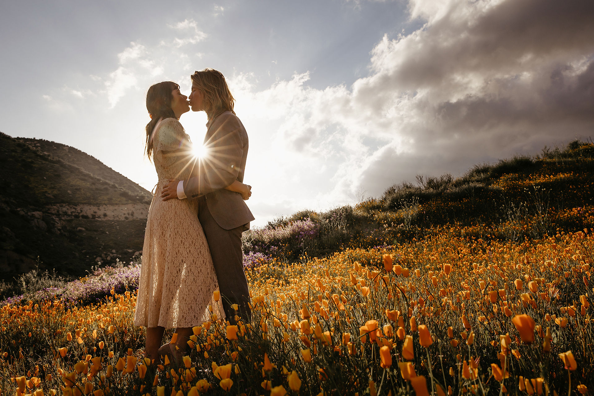 wedding elopement couple kiss in the poppy wild flower super bloom at sunset