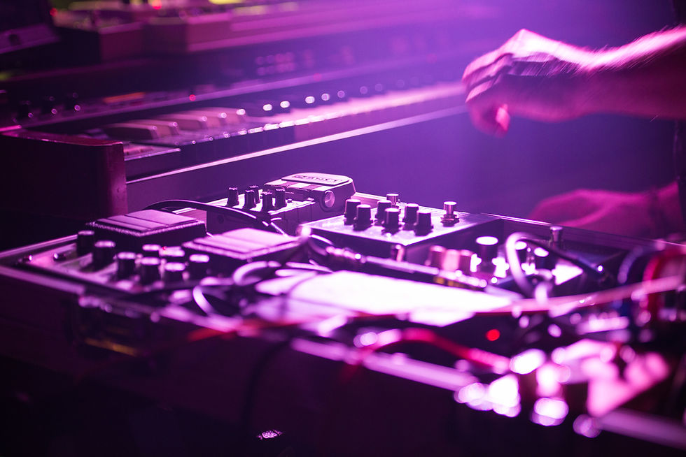 Los Angeles DJ mixing during a live performance under pink stage light