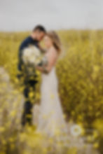 Bride and groom embrace on a trail of yellow wildflowers at their destination elopement wedding