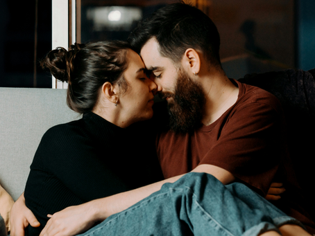 a young couple sitting on the couch together