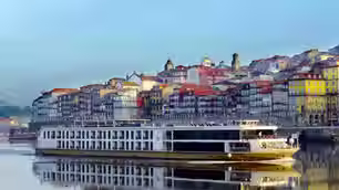 View of the AmaVida River Cruise ship sailing past a city in Portugal on the Douro river