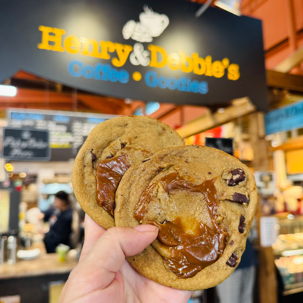Hand holding up cookies in front of stall