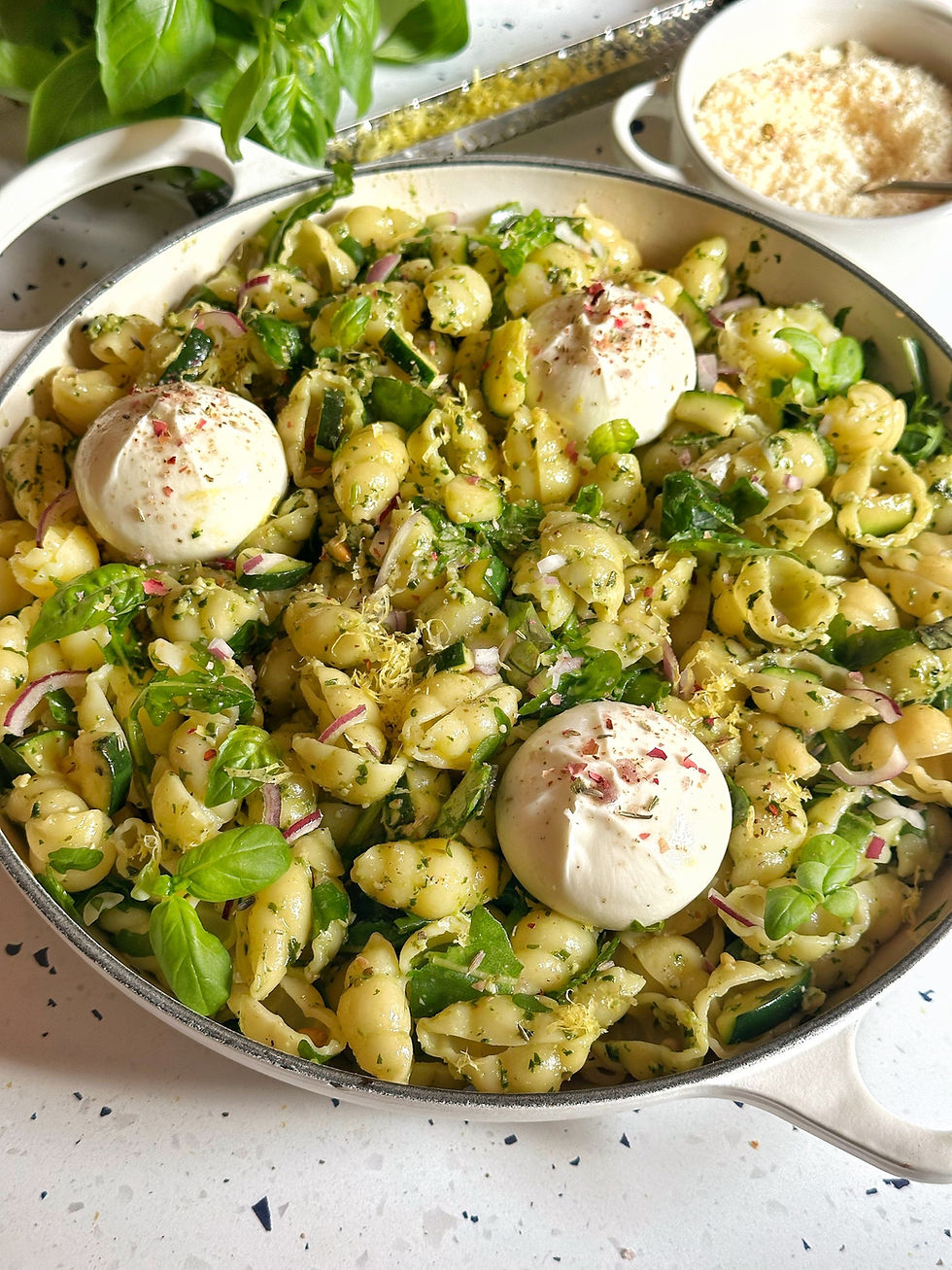 bord met pastasalade met cebakken courgette, rucola, pijnboompitten en burrata