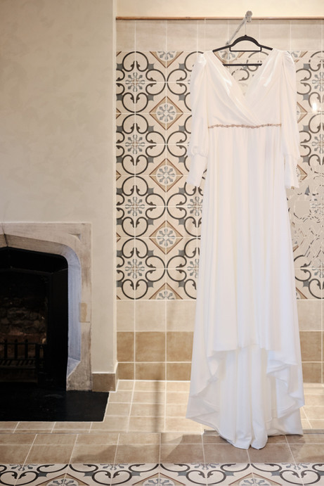 A wedding dress hung in a bathroom