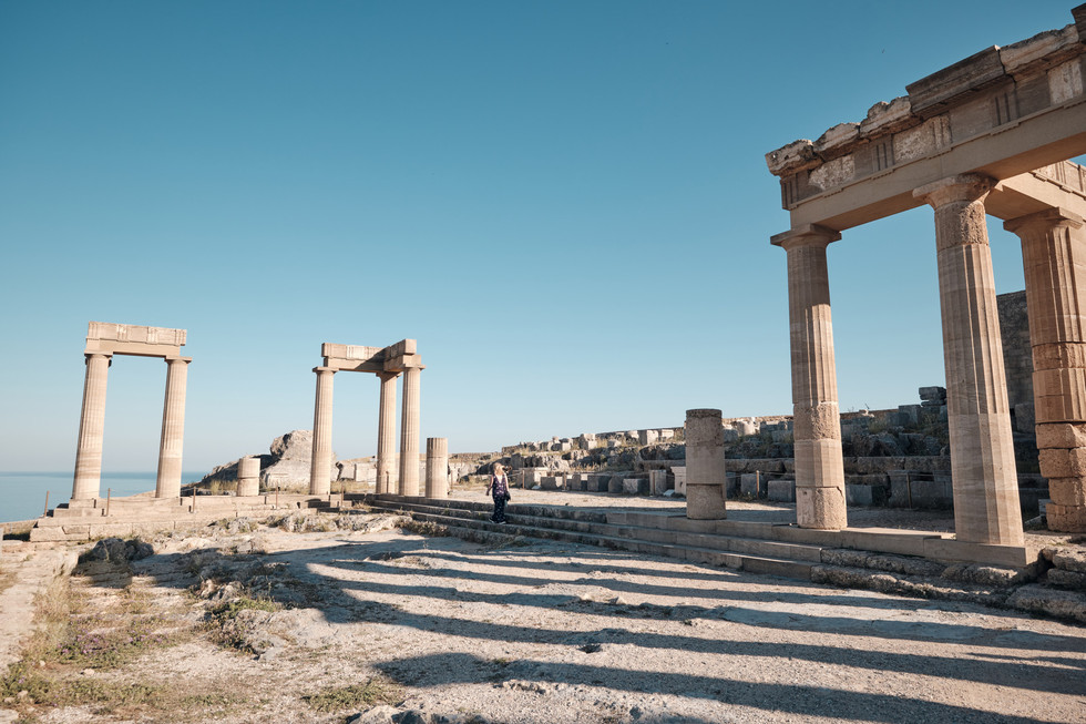 Long shadows created by the columns and setting sun at the Acropolis in Lindos