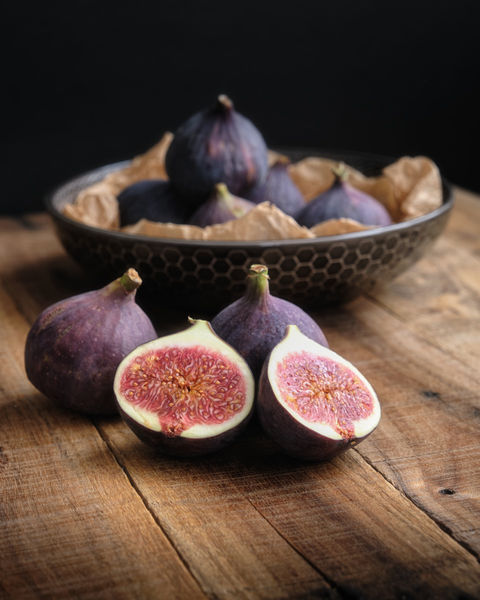 Image of some figs with a bowl of figs in the background. Food photography