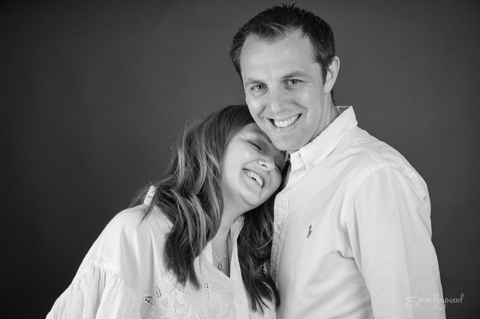 Young couple in white shirts against a dark background
