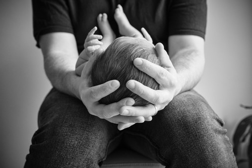 New dad holding the top of his son's head