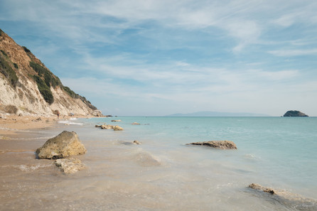 Veiw looking along beach in kefalonia with the turquiose sea lapping the sand