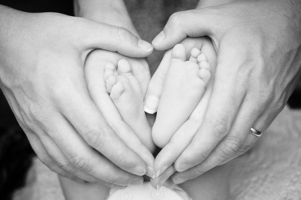 New parents holdng their childs feet