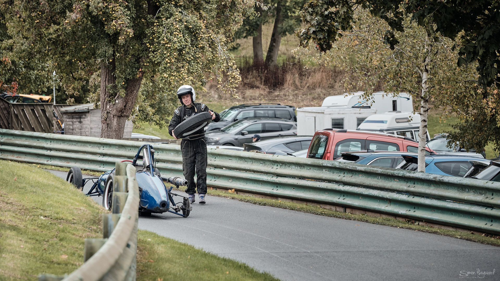 Driver recovering wheel from Prescott Hill after it fell off during race