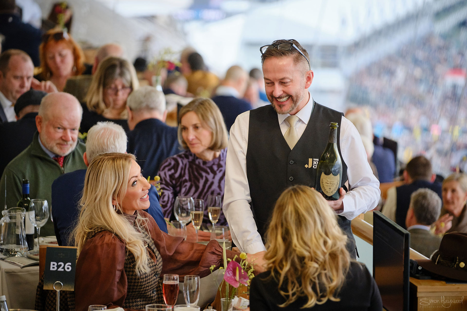 a waiter smiles and chats with guests in the Cheltenham Panoramic restaurant