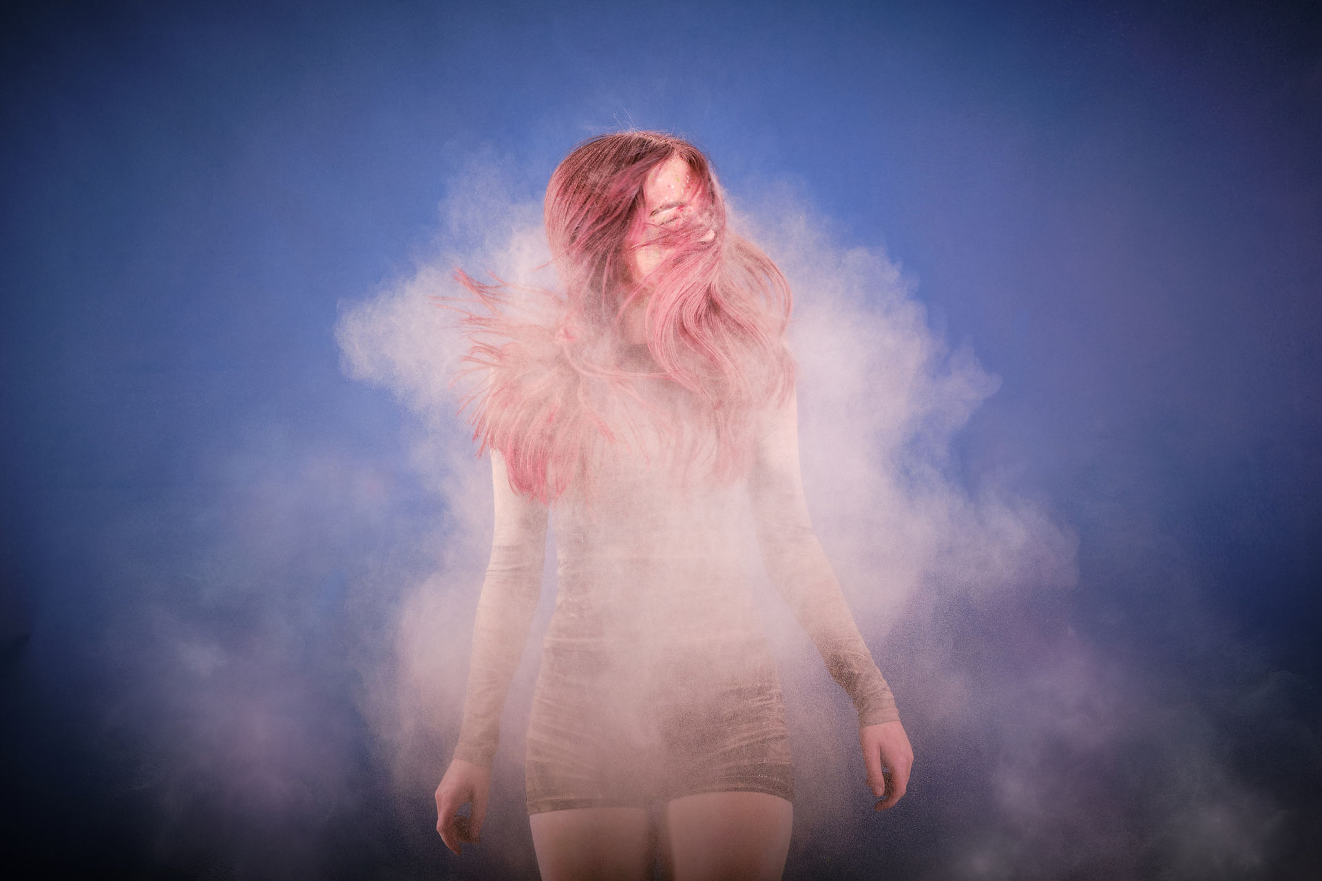 Young girl shaking coloured powder from her hair after a dance photography shoot.