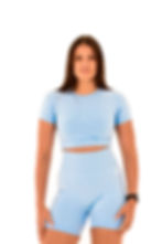 Model in lichtblauw shirt kijkt recht vooruit met ontspannen houding – toont de cropped pasvorm aan de voorkant.