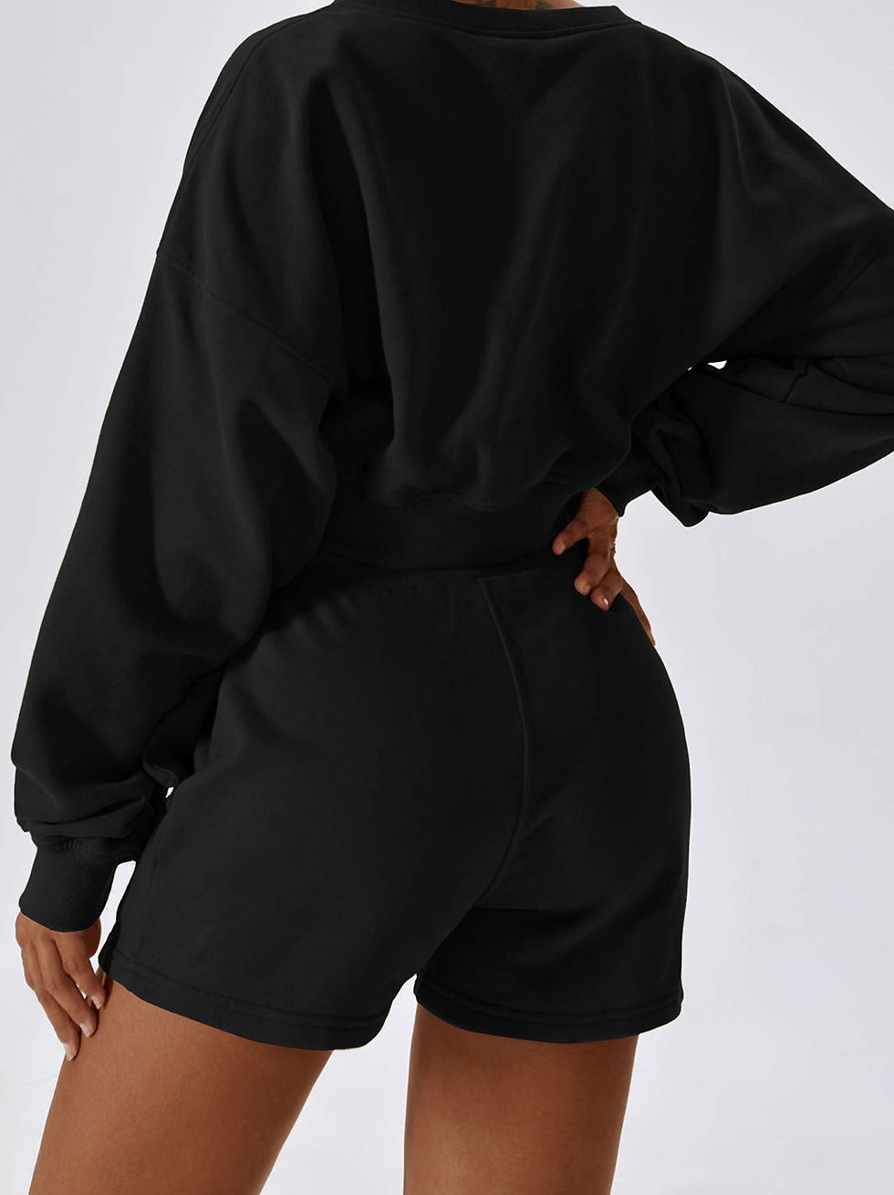 Thumbnail: Lounge Short in zwart – close-up op achterzijde, cropped sweater erboven