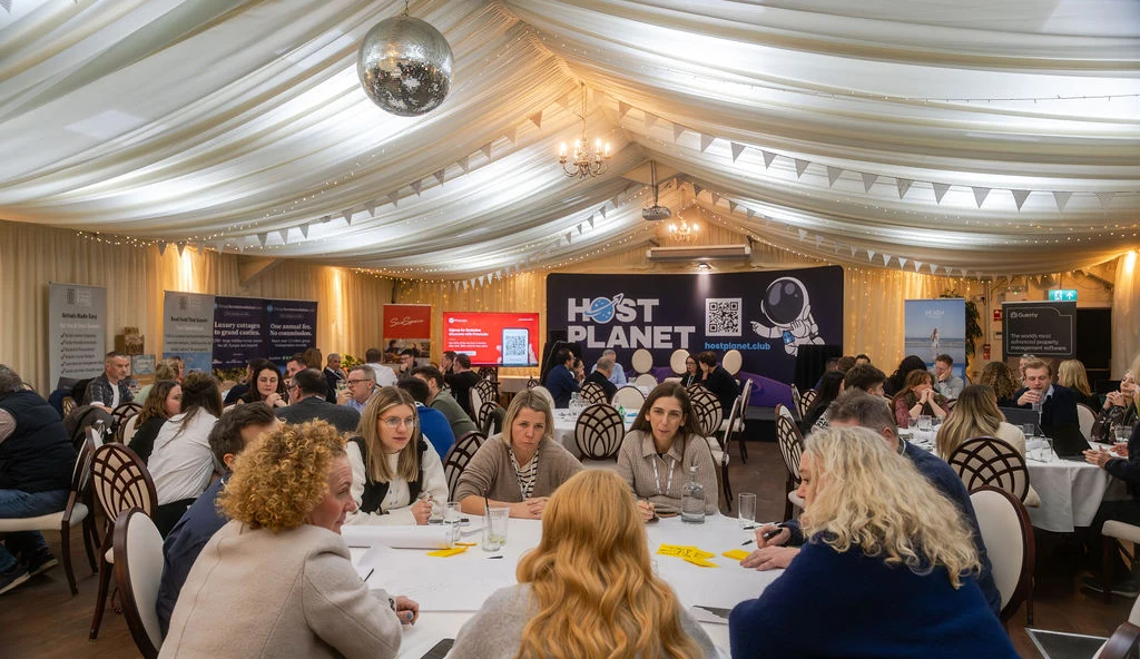 Attendees taking part in roundtable discussions beneath the Host Planet backdrop in Cornwall