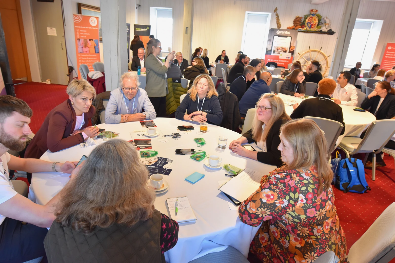 Attendees gathered around tables with notes and refreshments at the Portsmouth Roadshow