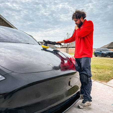 car detailer doing a paint correction on a black painted tesla in edmond oklahoma