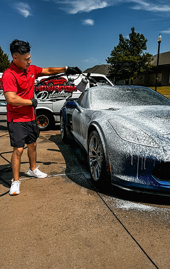 Detailing technician performing exterior mobile car detailing in Oklahoma City on blue corvette c7 z06