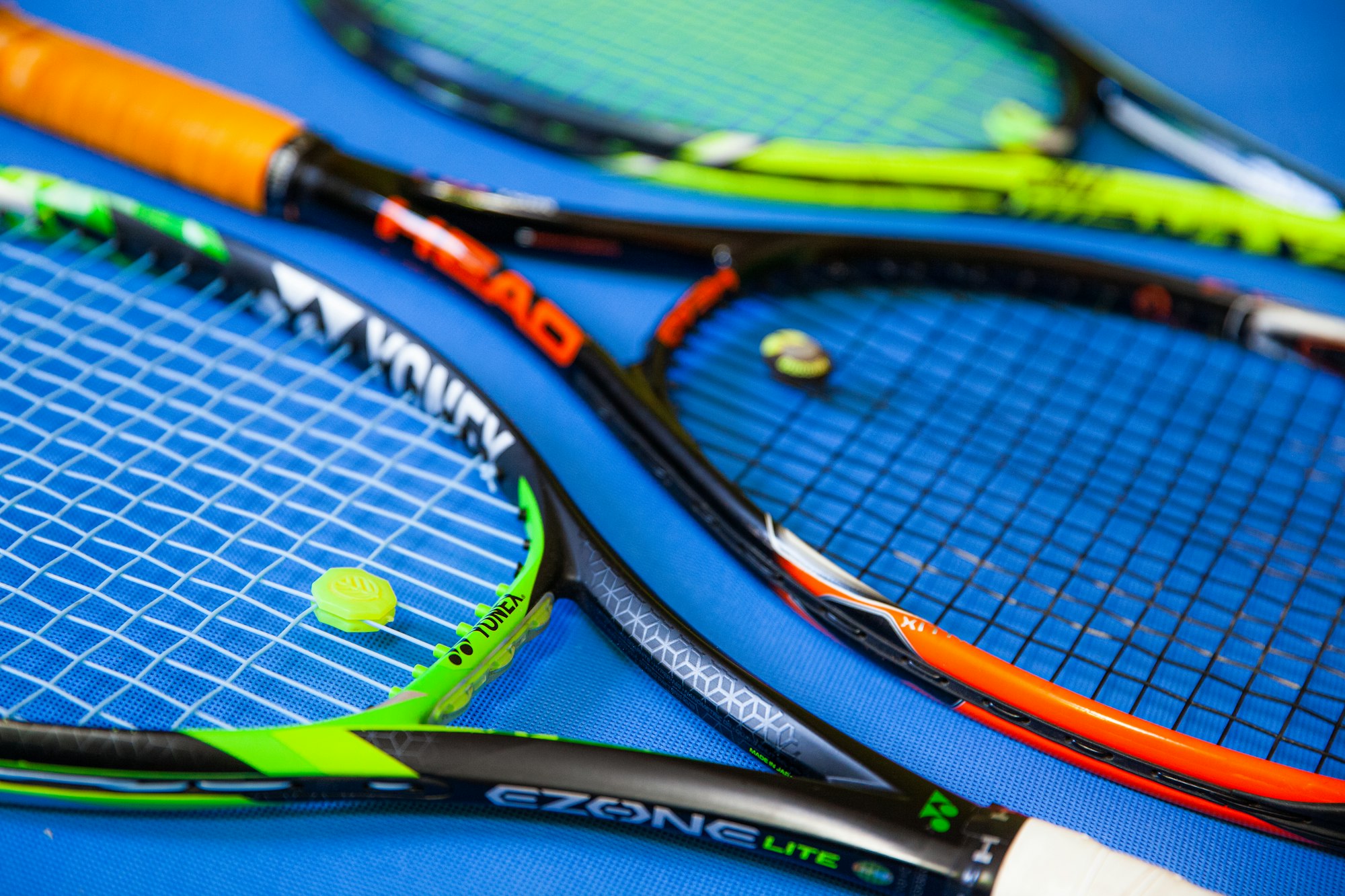 Three tennis rackets with different string setups, the starting point for choosing a hybrid tennis stringing setup